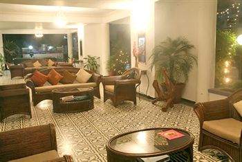 A lobby with wicker furniture and a fireplace, depicting Portuguese heritage and tradition.