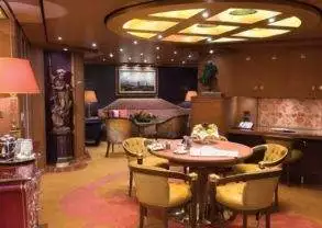 Experience the opulent luxury of a living room in the penthouse suite while cruising on Holland America Line.