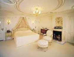 Lady Marjorie's Suite, a large white bedroom with a fireplace and ornate ceiling, on Luxury Sea Cloud Cruise.