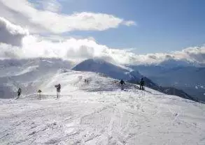 A group of people skiing on a snow covered mountain at a family-friendly ski resort in the Canadian Rockies.