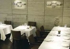 A dining room with white tables and chairs featuring excellent Basque cuisine at Arzak.