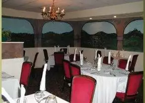 A dining room with red chairs and a mural on the wall at Barresi's Italian Restaurant in Cincinnati.