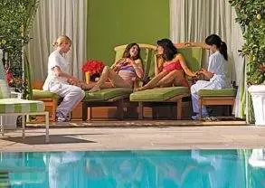 A group of Glam-Girls relaxing around a pool on their Beverly Hills getaway.