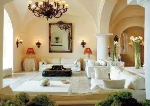 A living room with white furniture and a chandelier at the Capri Palace Hotel & Spa.