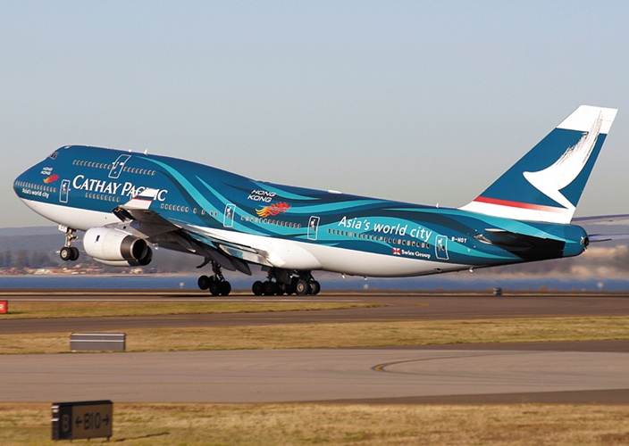 A large Cathay Pacific Airways airplane is taking off from the runway.