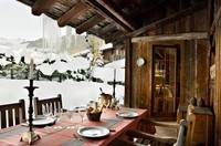 A rustic wooden cabin surrounded by snowy serenity.