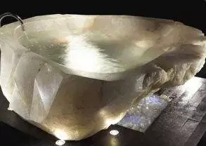 An extravagant crystal bathtub carved from a large piece of rock.