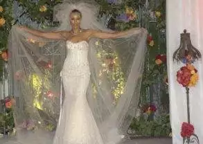 A woman wears a wedding dress while walking down the aisle for a diamond-studded wedding.