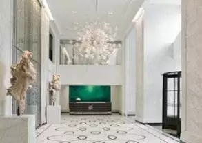 The Elysian Hotel - Chicago: A luxurious hallway with marble floors and a chandelier.