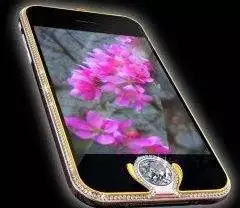 A diamond adorned cell phone with a pink flower on it.