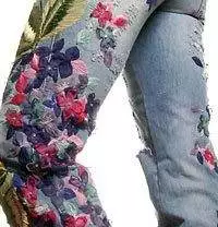 A woman wearing floral jeans.