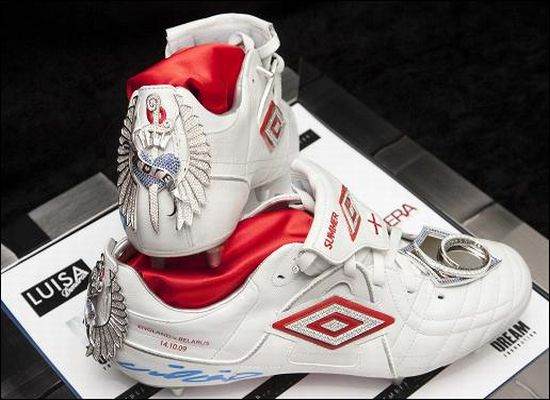 A pair of white soccer shoes with a red and white design priced at $128.
