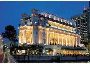 The Fullerton Hotel, a large building in the middle of a city at night, invites you to go global.