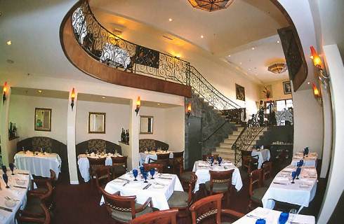 The inside of California's Greystone the Steakhouse with a spiral staircase.