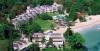 Aerial view of the posh Sans Souci Resort in Jamaica, a beachfront retreat featuring pools, lush gardens, and elegant buildings surrounded by trees and a sandy shore.