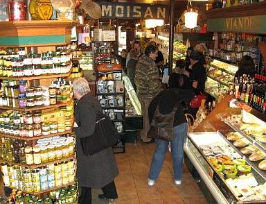 People shopping in a grocery store with many different kinds of food in Quebec City, blending old world charm with a new trendy flair.