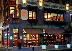 The Library Hotel - NYC: A restaurant at night on a city street corner.