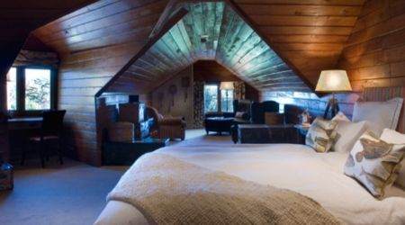 A rustic log cabin retreat with a cozy bed.