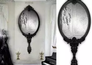 An ornate Marie Antoinette mirror resembling the mirror used in the Palace of Versailles sits in a room with a piano.