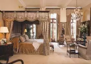An ornate bedroom with a four poster bed featuring Victorian lifestyle at the modern Milestone Hotel.