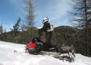 A person snowmobiling in Montana, Hooked on Snowmobiling::Glacier Country.