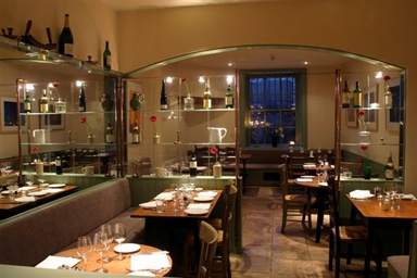 A restaurant with a glass wall offering natural flavors at The Moody Goose.