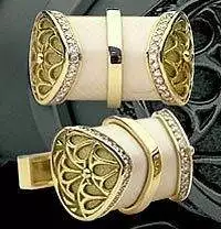 A pair of gold cufflinks with diamonds on them.