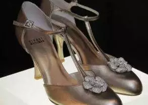 A pair of Stuart Weitzman gold shoes on display.