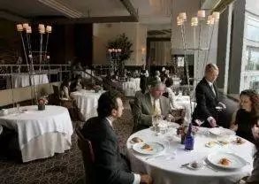 A group of people sitting at a table in a restaurant, Taste the Exclusive Five-Course Meal at Per Se - NYC.