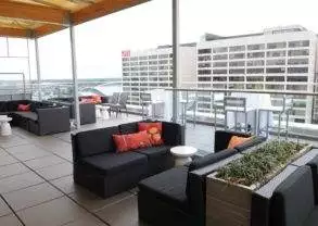 A rooftop patio at the Glenn Hotel in Atlanta with black furniture and a view of the city.