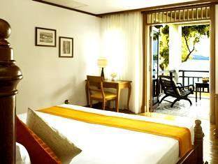 A bedroom with a balcony overlooking the ocean in an age old forest at the Rebak Island Resort.