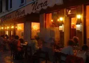 A group of people sitting at Olive Nera restaurant in Venice, Italy at night.