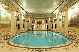 An ornate building featuring an indoor swimming pool that allows you to go back in time and live life king-size.
