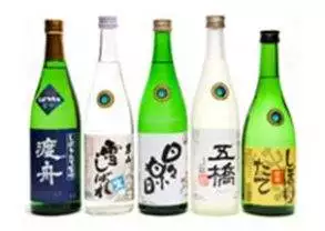 A group of bottles with Japanese writing on them that make Dai Ginjo Sake.