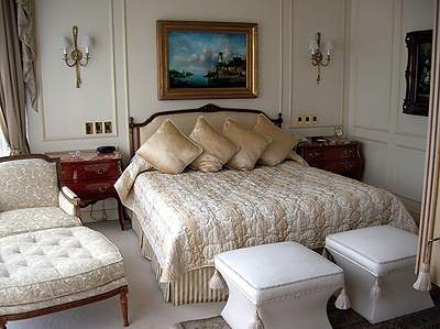A bedroom with an ornate bed and chairs featuring the view of the Andes.