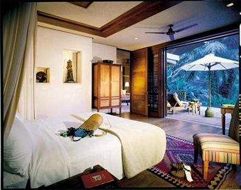 Experience Indonesian luxury in a spacious bedroom equipped with a sliding glass door.