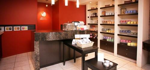 A coffee shop in Edmonton with red walls and shelves.