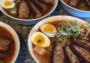 Four bowls of soup with meat and eggs prepared by MD chef.