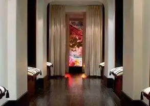 A long hallway with luxurious benches and a captivating painting.