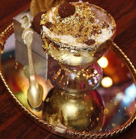 A bowl of ice cream on a tray with a spoon, offered at Serendipity 3.