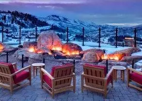 A fire pit sits in the middle of a snowy mountain at St. Regis Deer Valley in Utah, pampering guests with natural beauty amidst interior luxury.