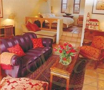 A living room with historical purple furniture and a fireplace for a royal accommodation at Tower Lodge.